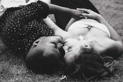 灰度图的男人和女人面对面躺在草地上
